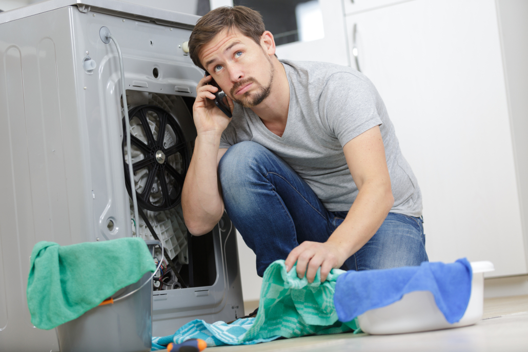 young man on the phone durin washing machine repair service